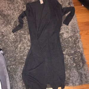 long dark grey sweater with pockets and slits.